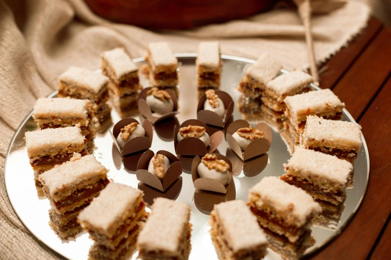 small sandwiches are stacked on a plate with little cookies on it