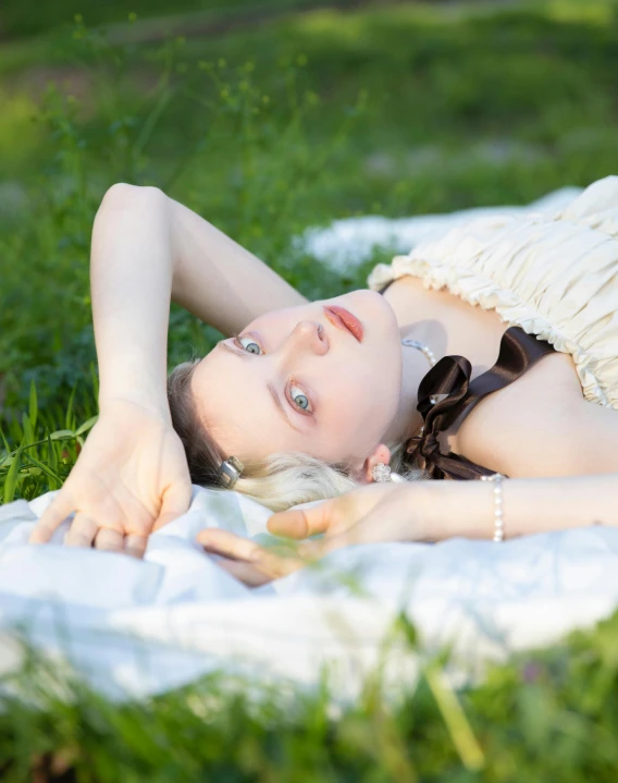 the woman is laying on her back on the towel