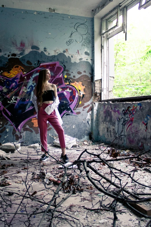 a girl posing in the midst of a graffiti - filled wall