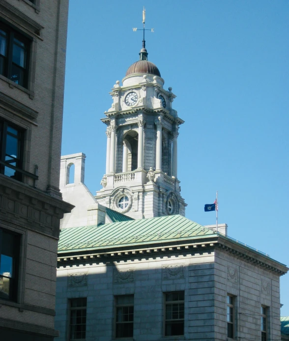 a large white and grey building has a steeple with a clock