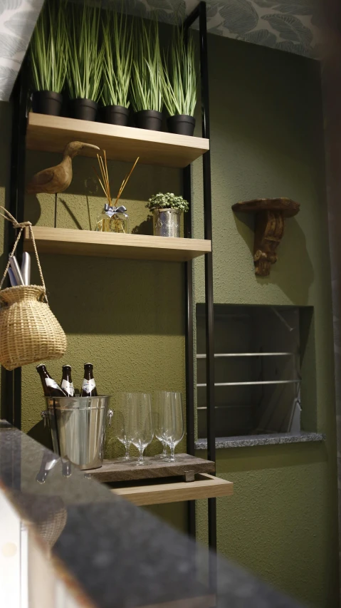 three shelves, one filled with bottles and wine glasses