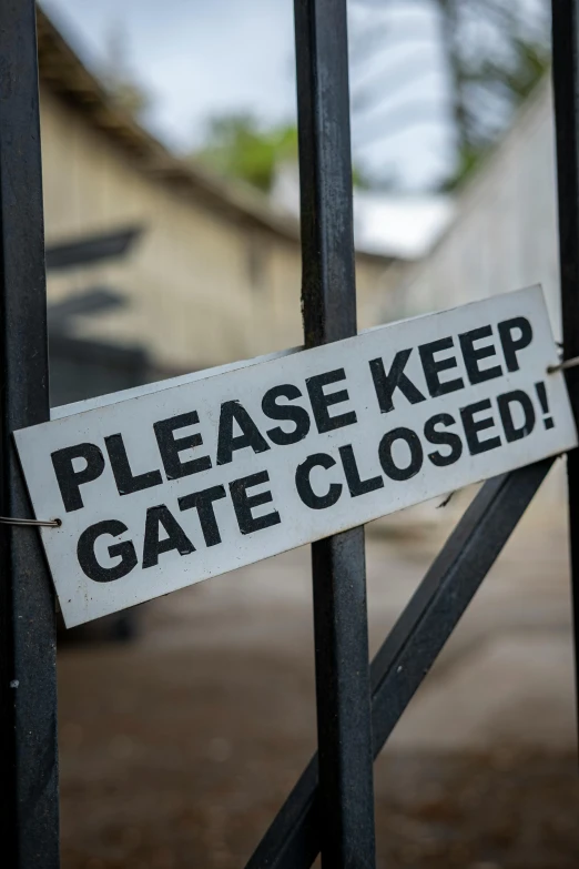 a sign posted on an iron gate that reads please keep gate closed