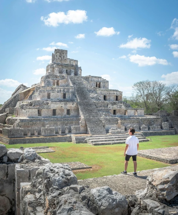 a man is standing in front of a very old building