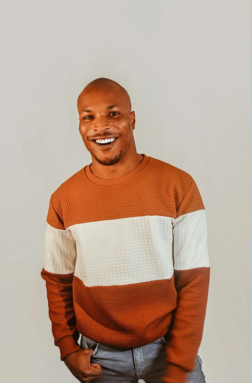 smiling man in a sweater with hands in his pockets