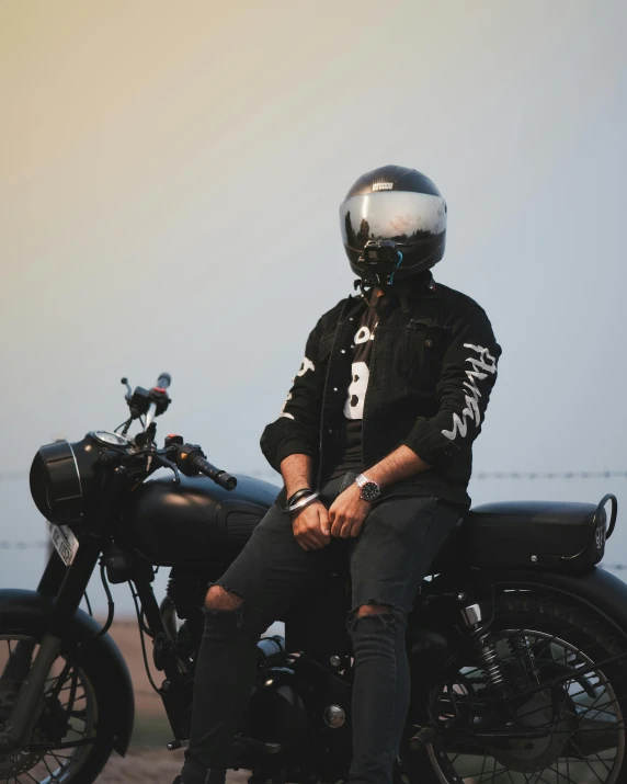 a person on a motorcycle sitting by some barbed wire