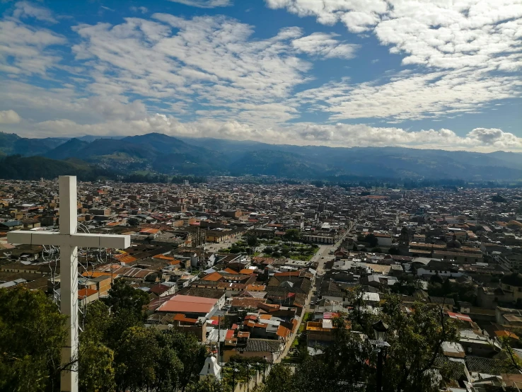 a view of the city with a cross standing in front of it