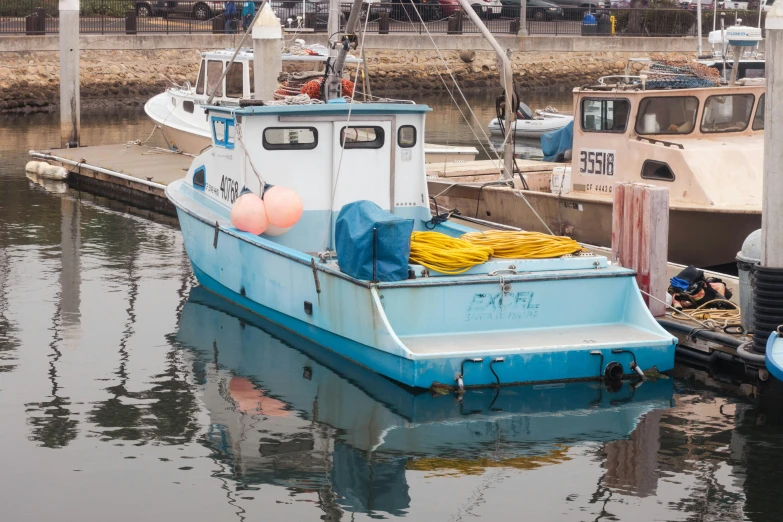a blue fishing boat tied up at the dock