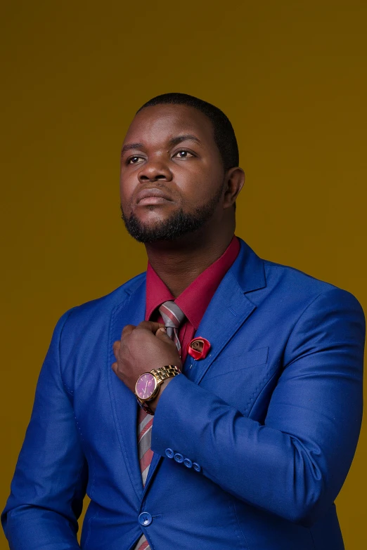 a man is standing wearing a bright blue suit and red shirt