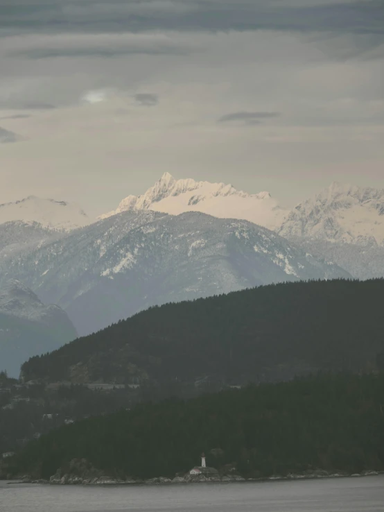 mountains range across a lake near a light house