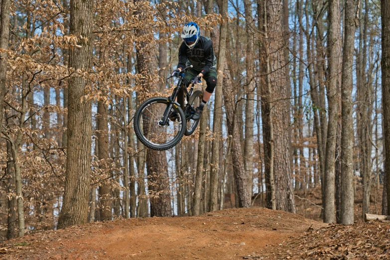 a person jumping a dirt trail with a bike