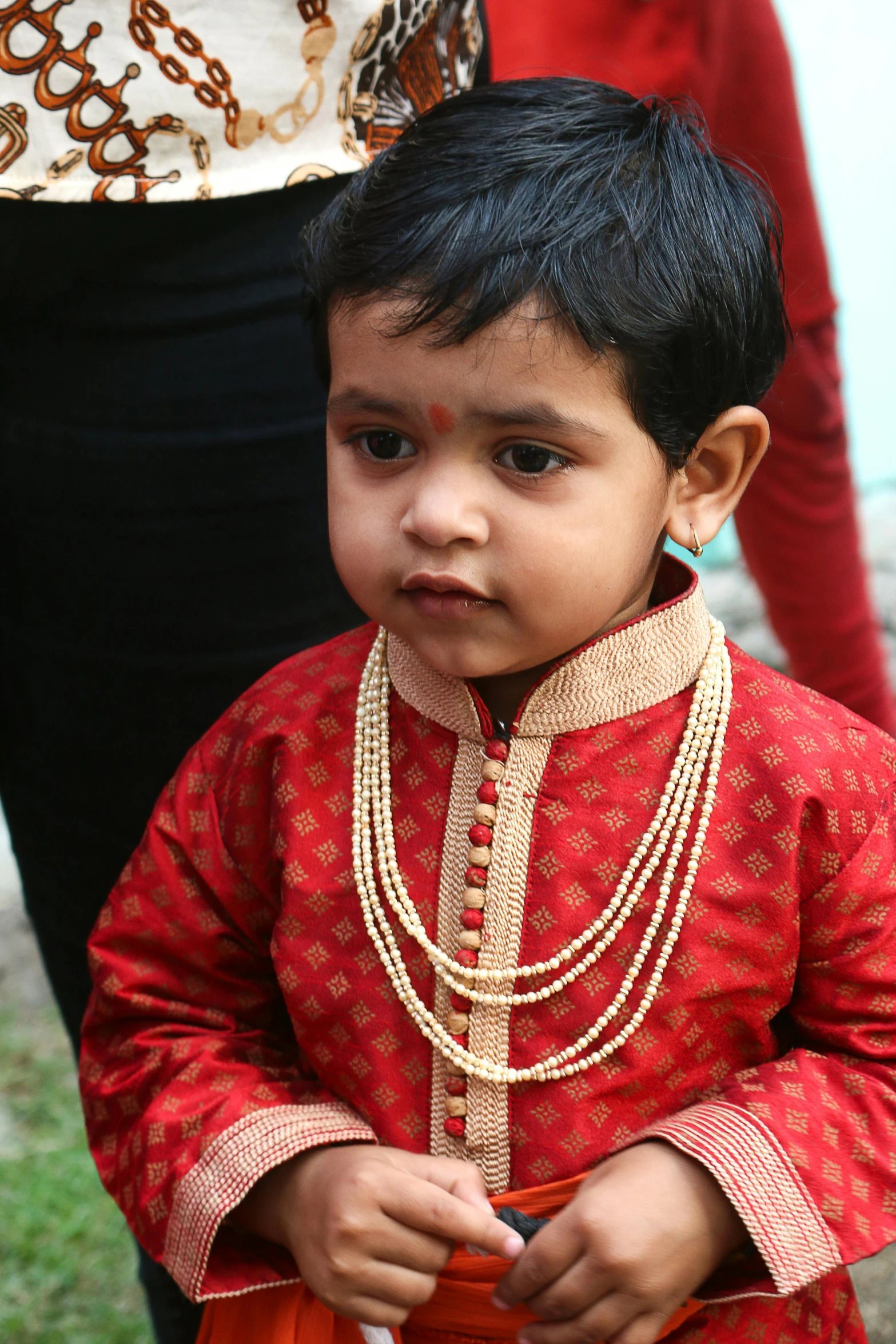 a small child is wearing some beautiful necklaces