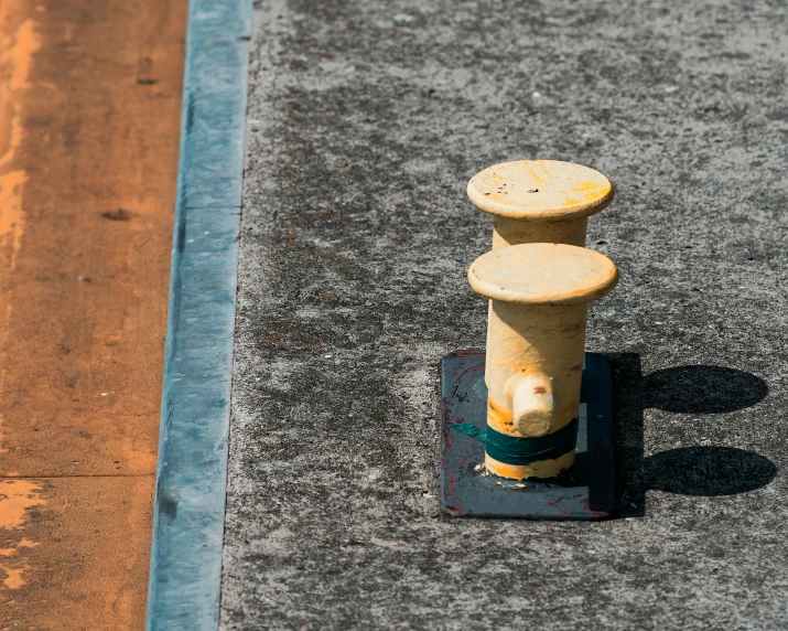 a yellow fire hydrant sitting on top of a paved road