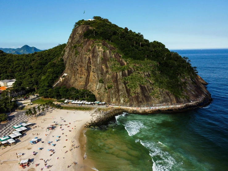 a large group of people on a sandy beach next to the ocean