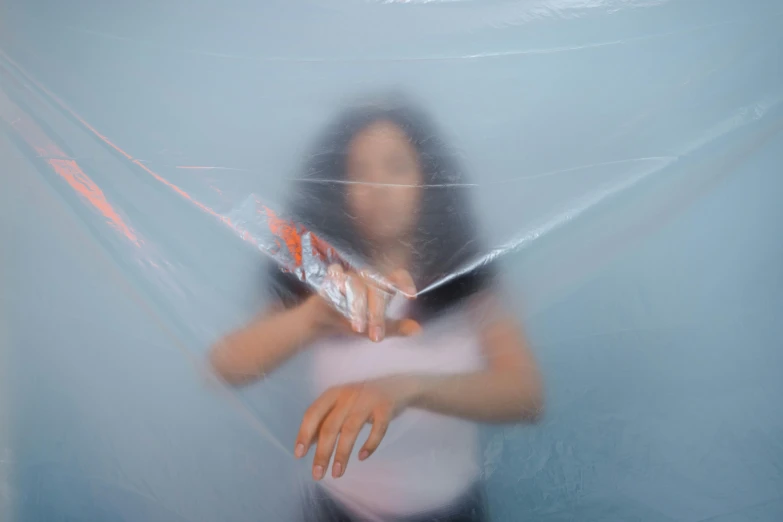 a woman holding a bag of doughnuts, in front of blue walls