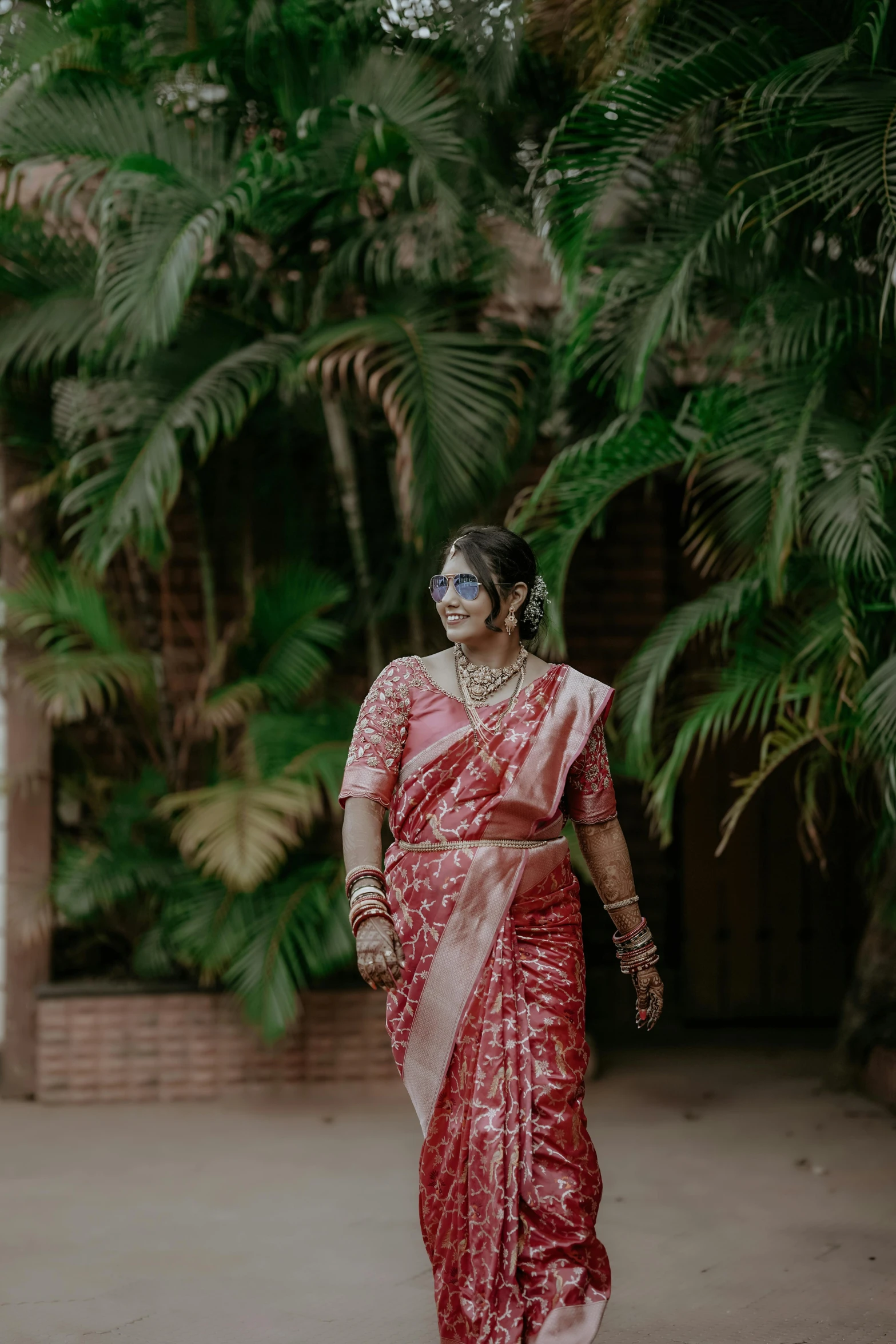 a woman standing outside wearing a red and white sari