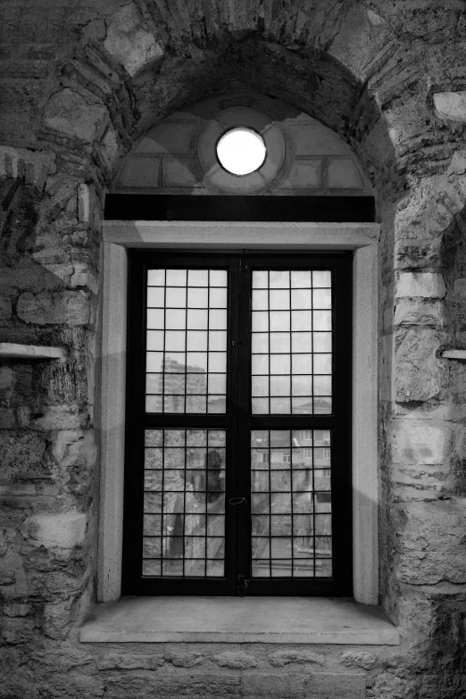 a black and white po of a window in an old building