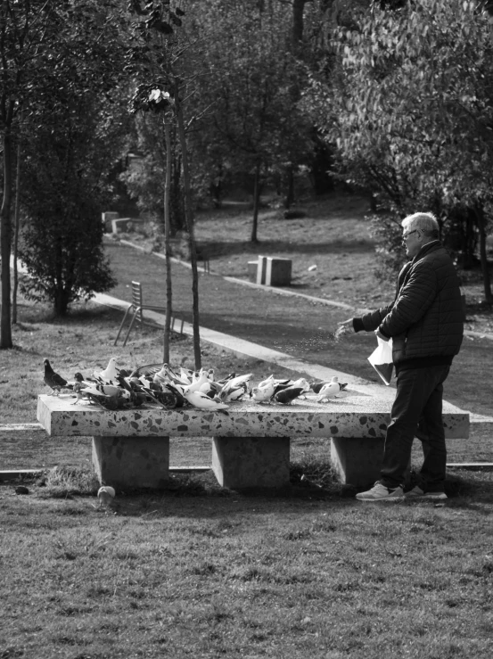 a man standing next to a stone table full of birds