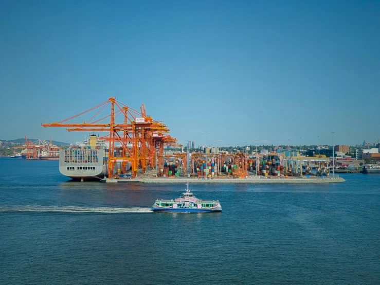 a boat going on the water next to a construction crane