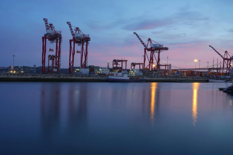 cranes are seen over the water at night