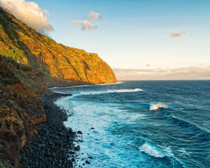 ocean waves lap over rocks and steep rocky coastline