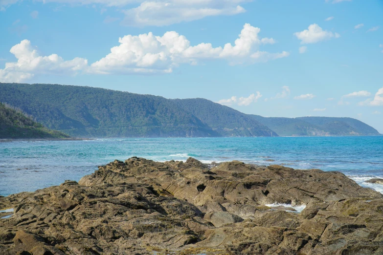 the rocky shore is surrounded by blue ocean