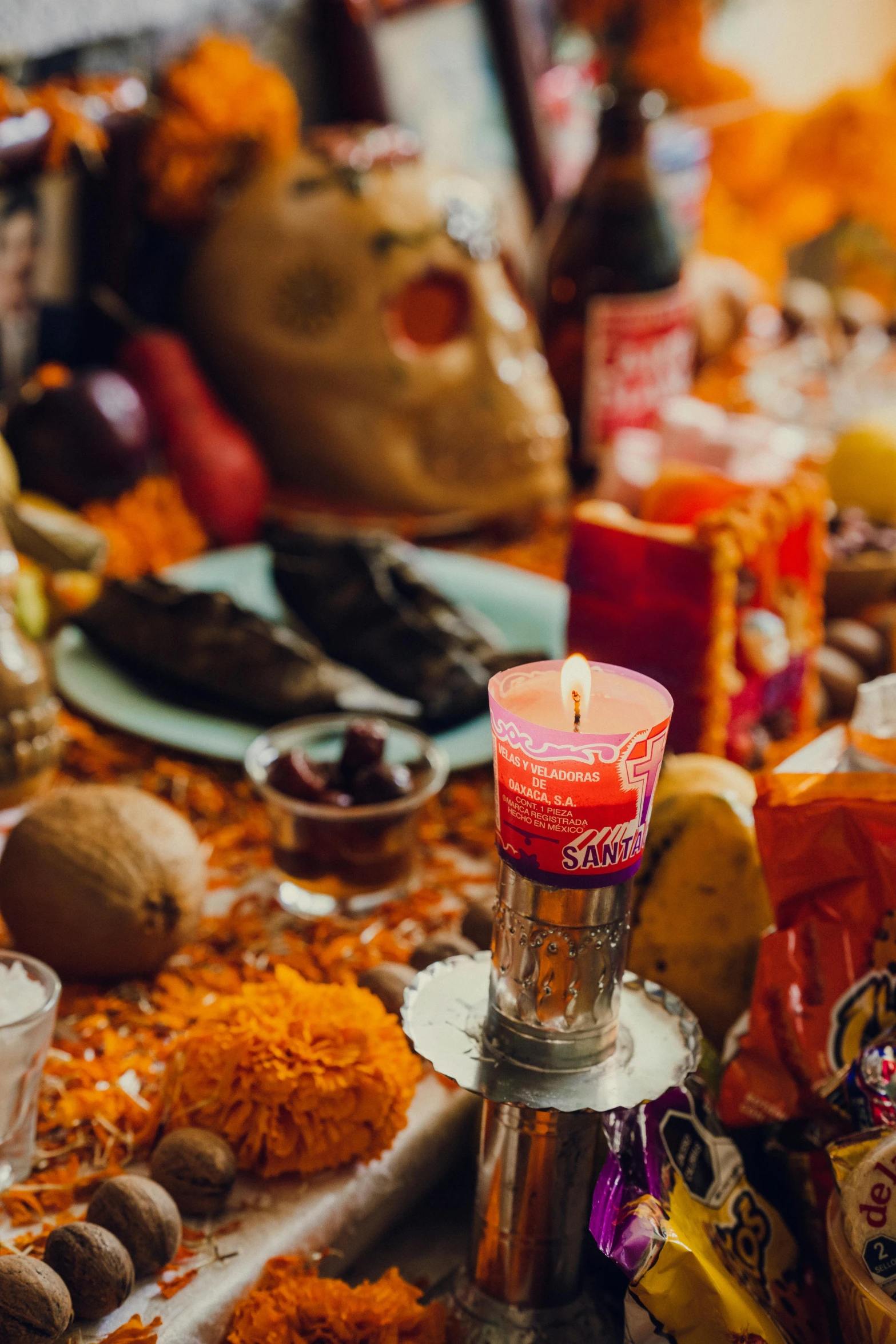 a table covered with orange flowers and candles