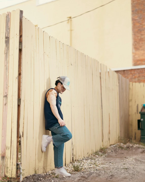 a man leaning against the side of a building