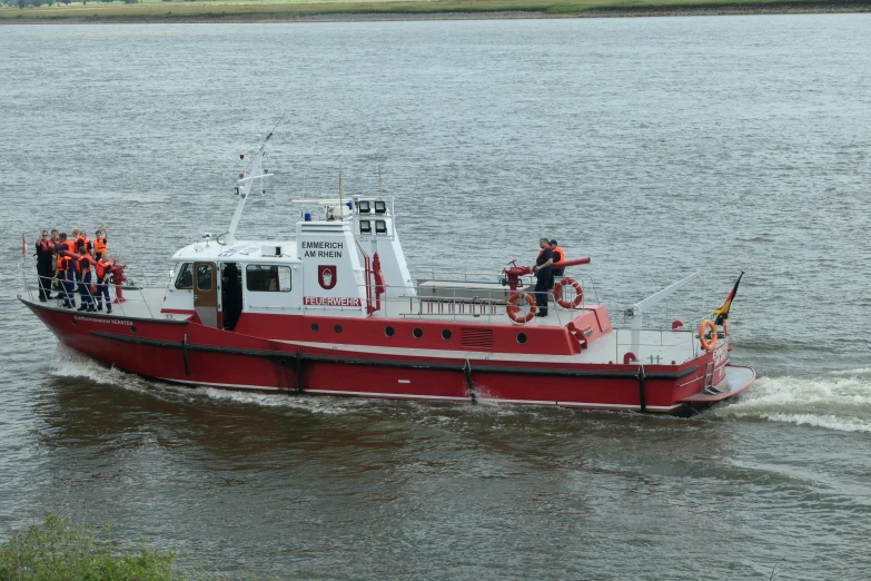 a red and white boat with several people on the bow