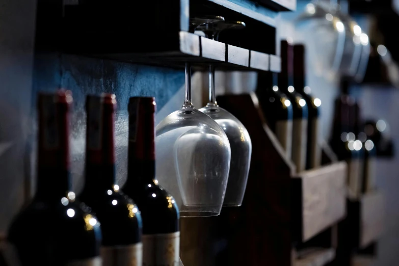 bottles and glasses sit on the back of a wall