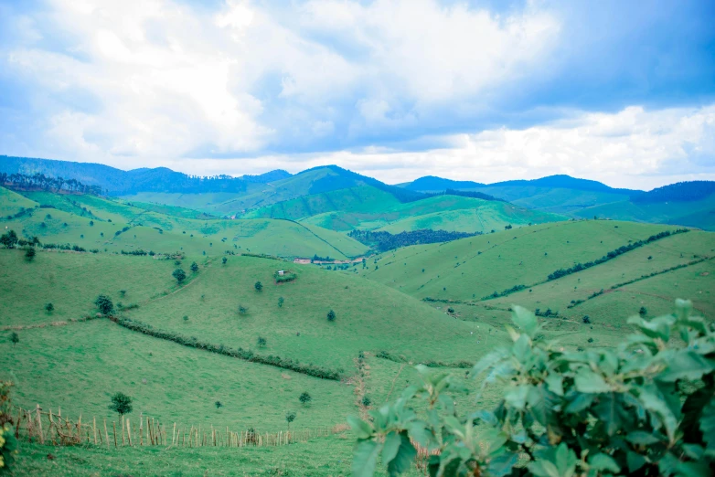 a beautiful green landscape with hills and a house