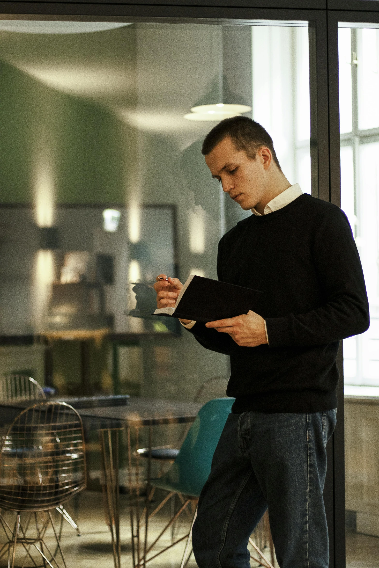 a man standing in an office looking at his cell phone