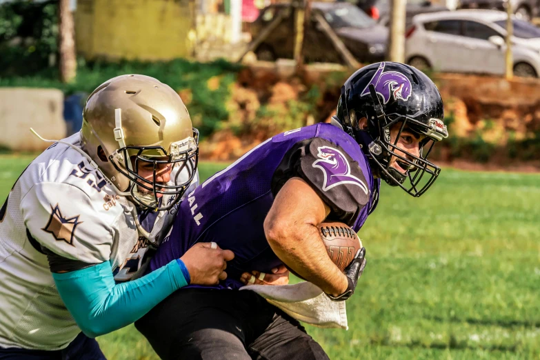 two football players are fighting for the ball