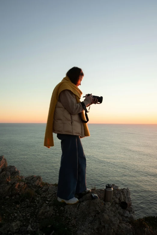 a woman standing on top of a hill taking a po