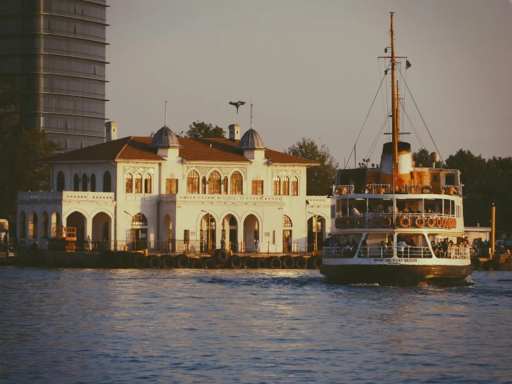 the large boat is passing the house in the water