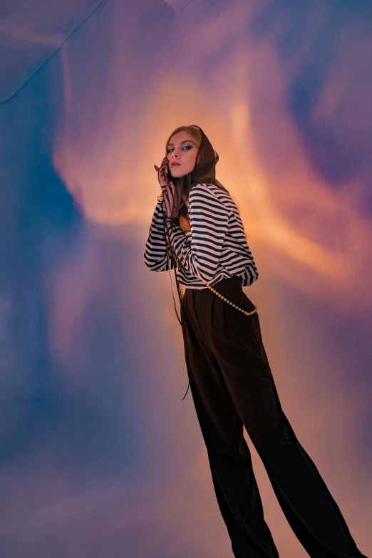 a woman is standing in a striped shirt