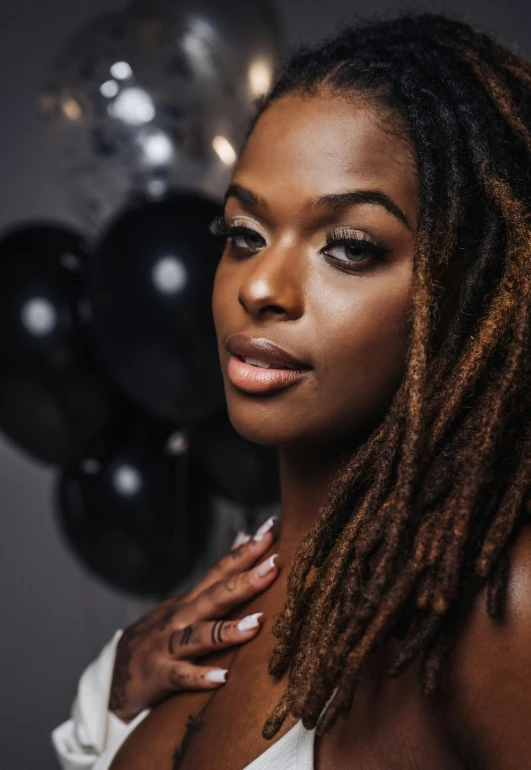 a woman wearing a white tank top and long dread locks