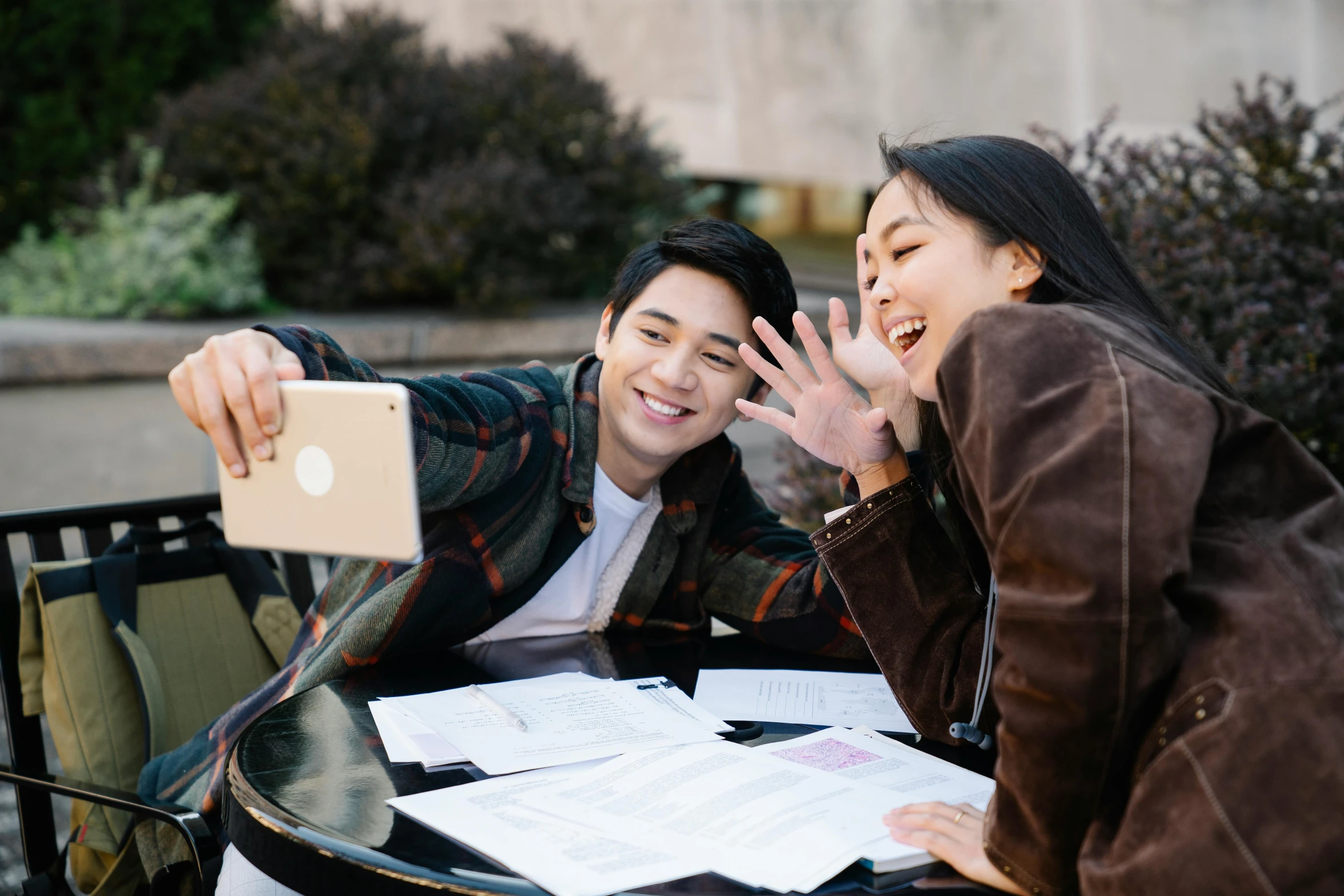 a man holding his arm out to a woman over a tablet