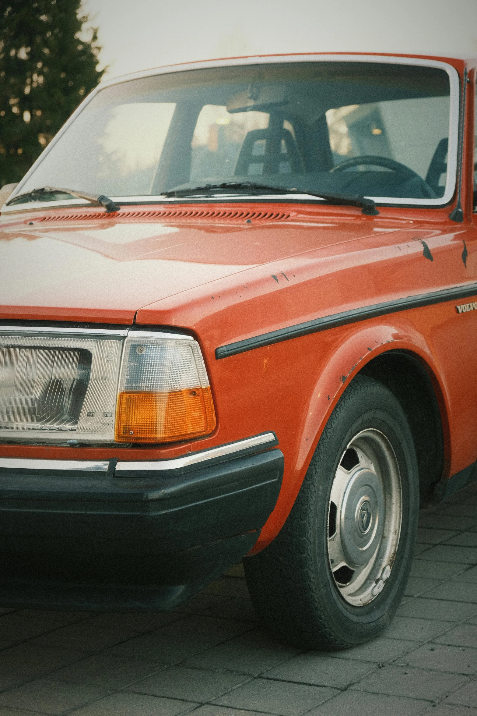 an orange car parked next to another car