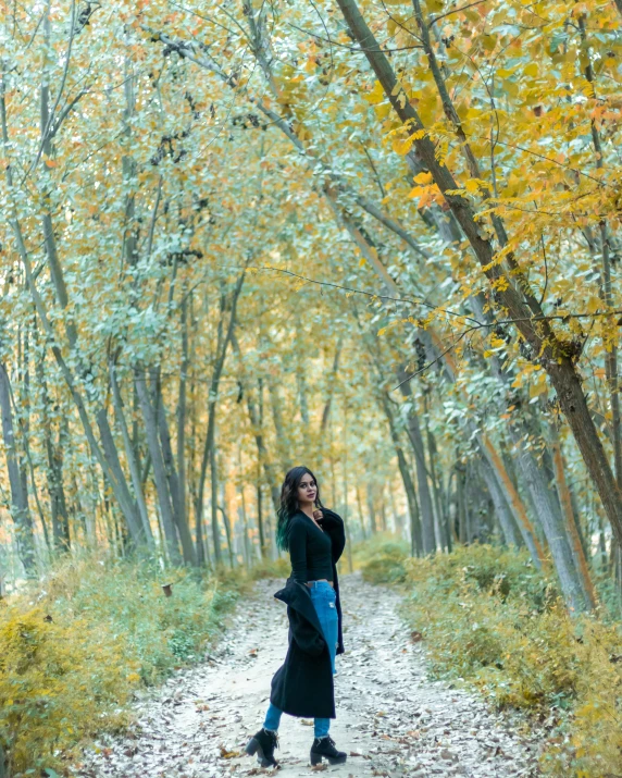 a woman is walking through the woods with her hand on her head