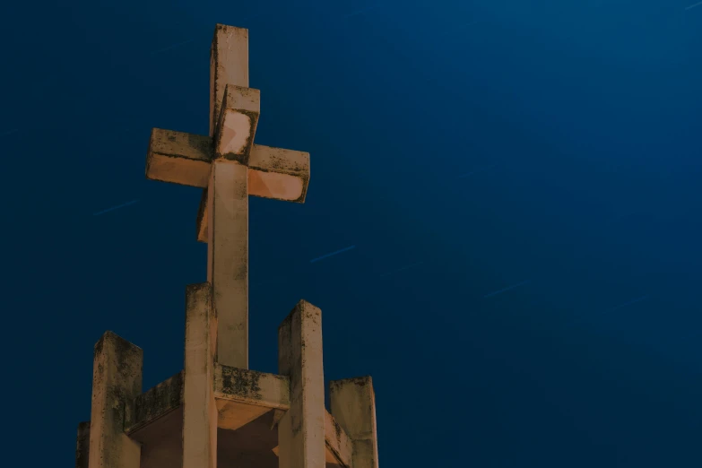 a tall wooden cross on top of a wooden structure