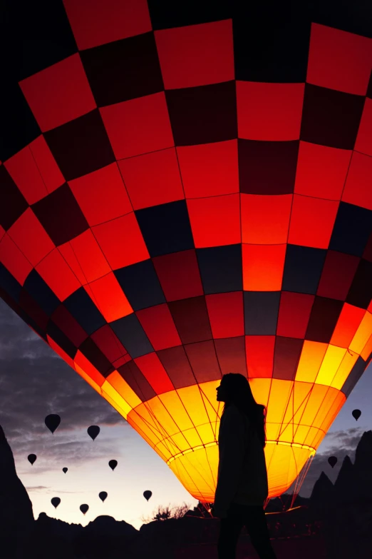 a silhouette of a person walking past  air balloons