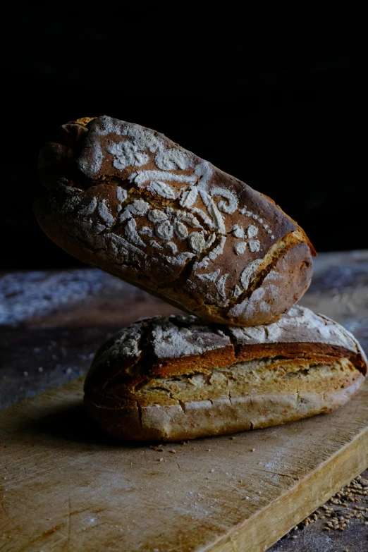 a piece of bread sits on top of another loaf of bread