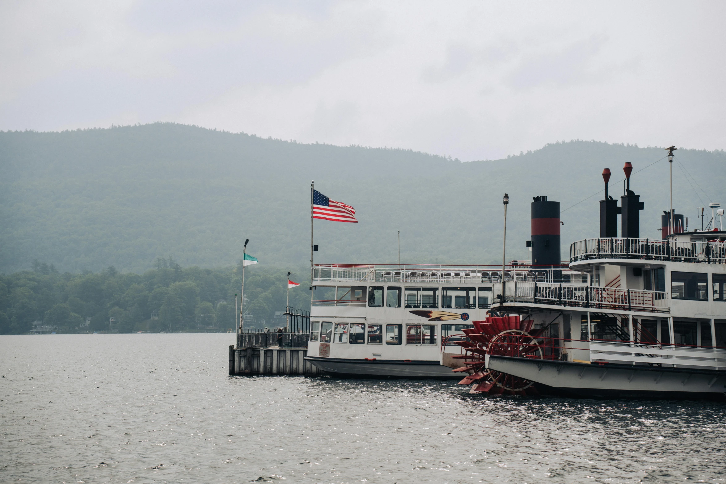 two white boats and an american flag are on the water