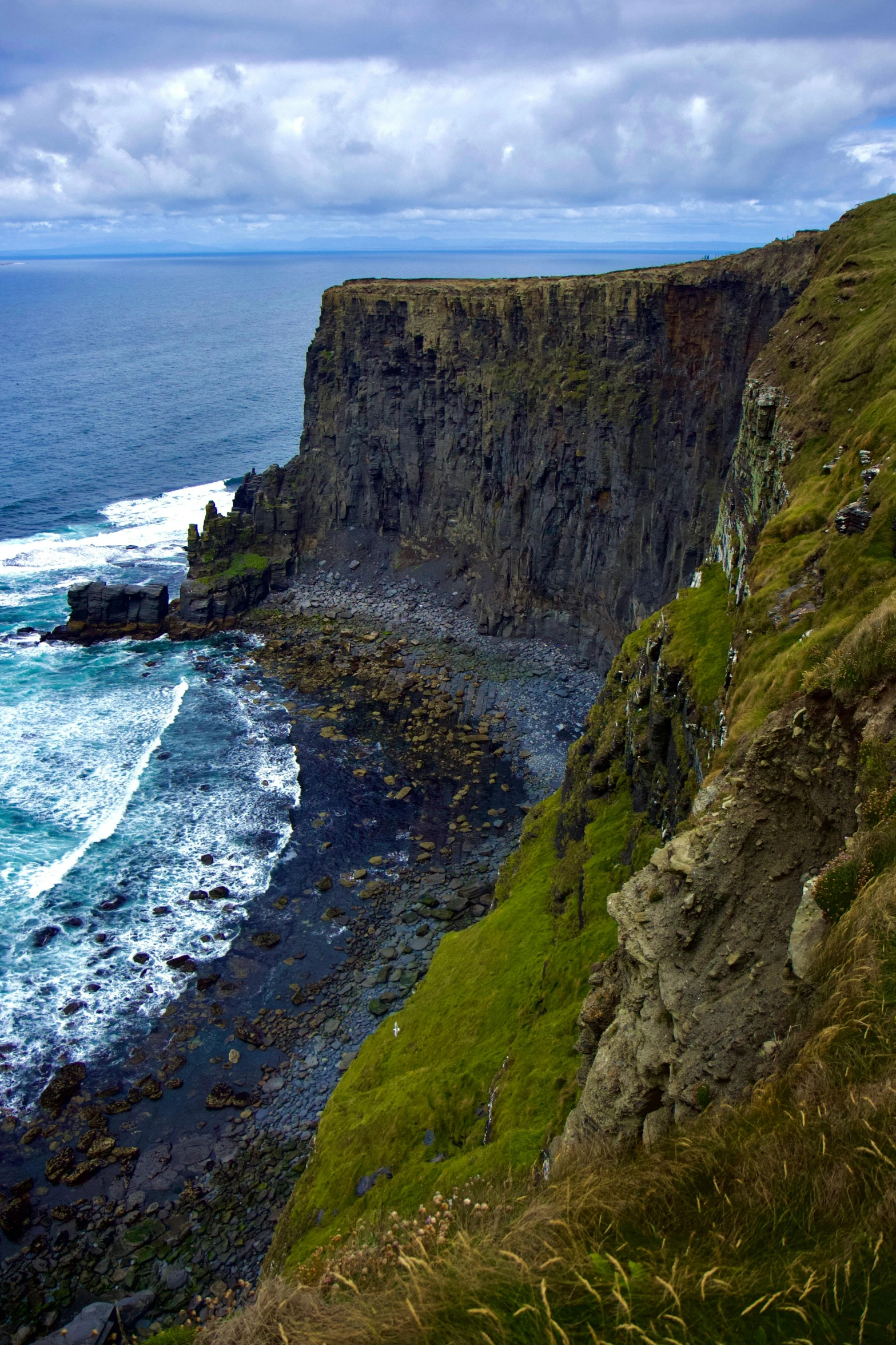 a rocky cliff with the ocean in front