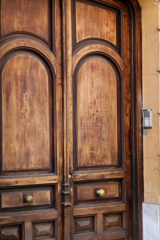 a close up of two wooden doors and a building