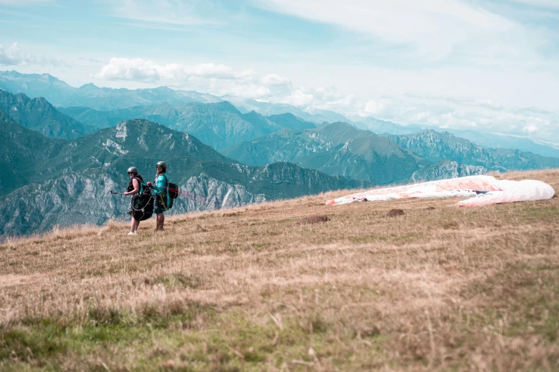 two people with backpacks hiking up a hill