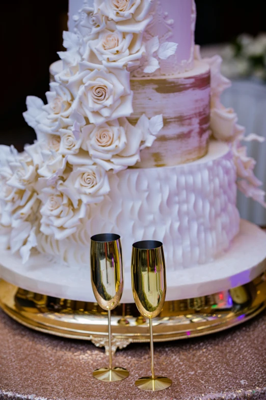 a three tier wedding cake with champagne flutes