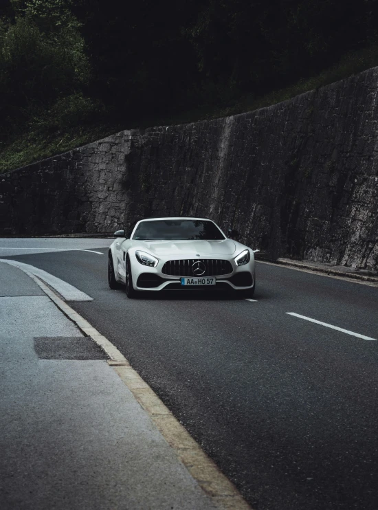 a white sports car driving down the road