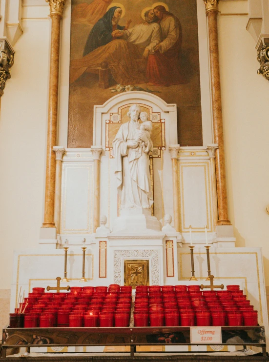 a tall white alter with red chairs in front of it