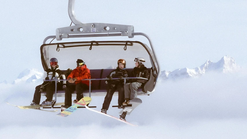 two people on a ski lift, each having their picture taken